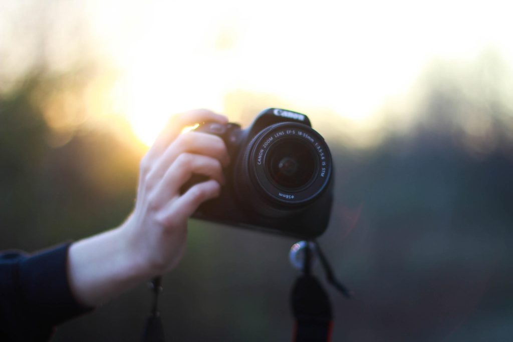 A Person Holding Up A Canon Camera