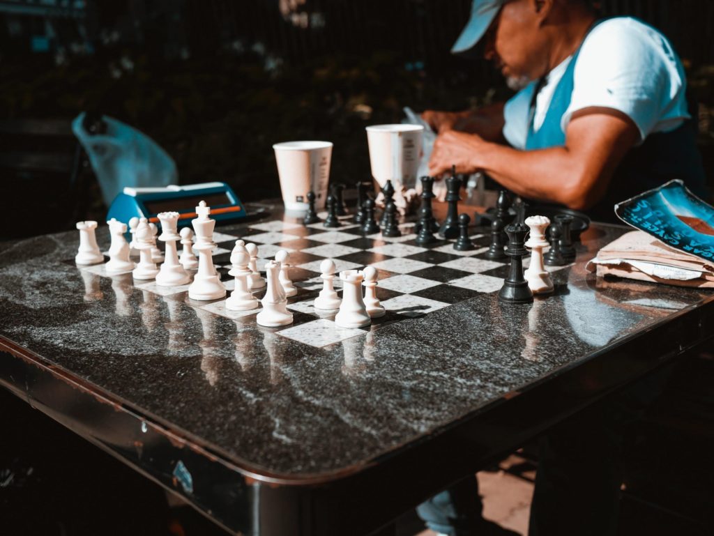 A Photo Of A Chess Piece With A Man Reading Newspaper
