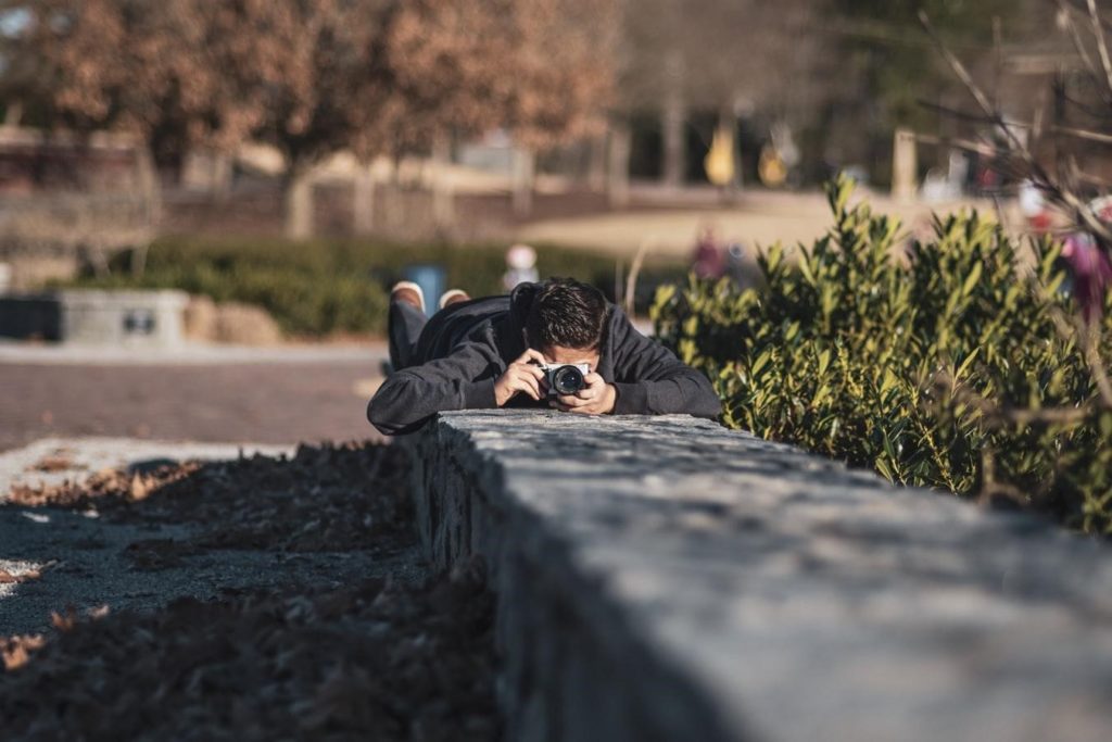 Man Taking A Photo Lying Down