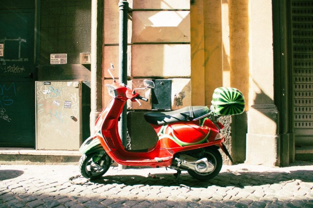 Red Scooter Motorcycle Parked In An Alleyway